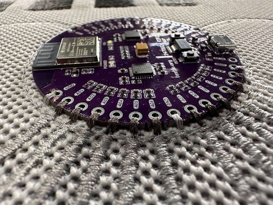Round sensor PCB stitched into stretch knit