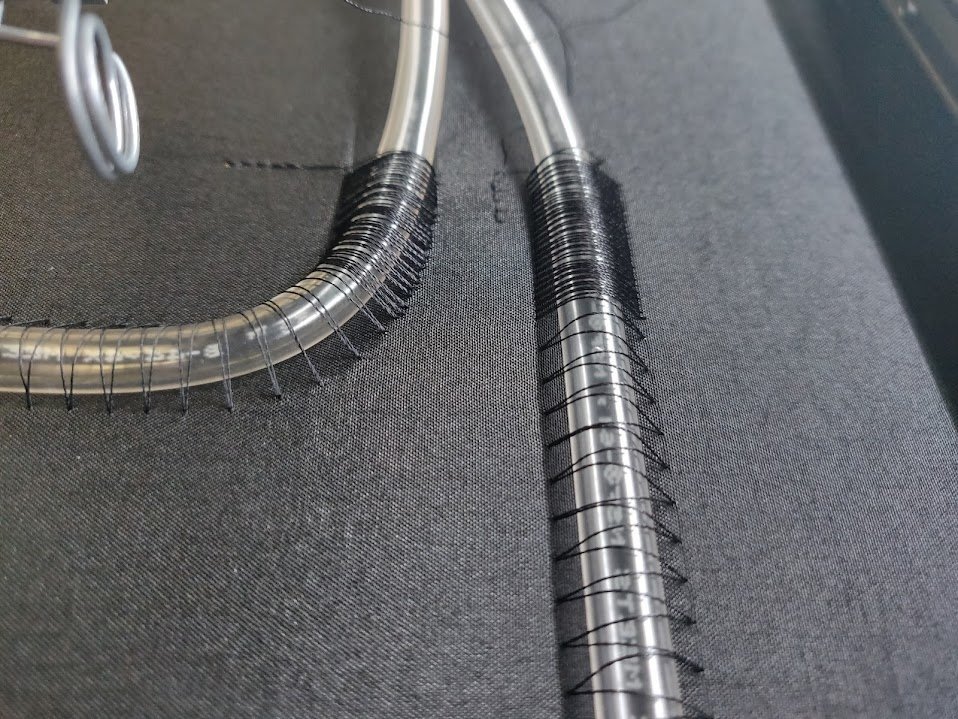 Close-up of couched clear tubing stitched to fabric