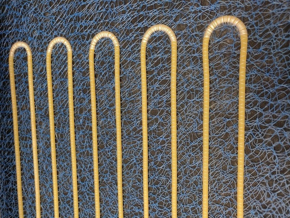 Yellow tubes routed in parallel rows on open mesh